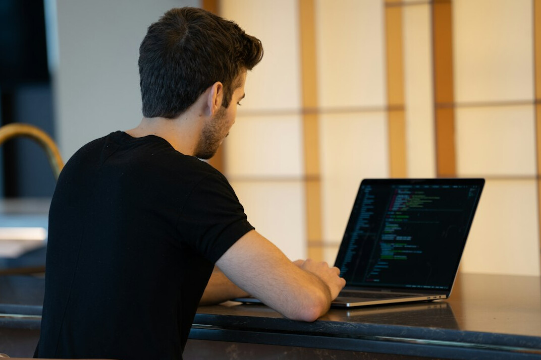 person coding on laptop