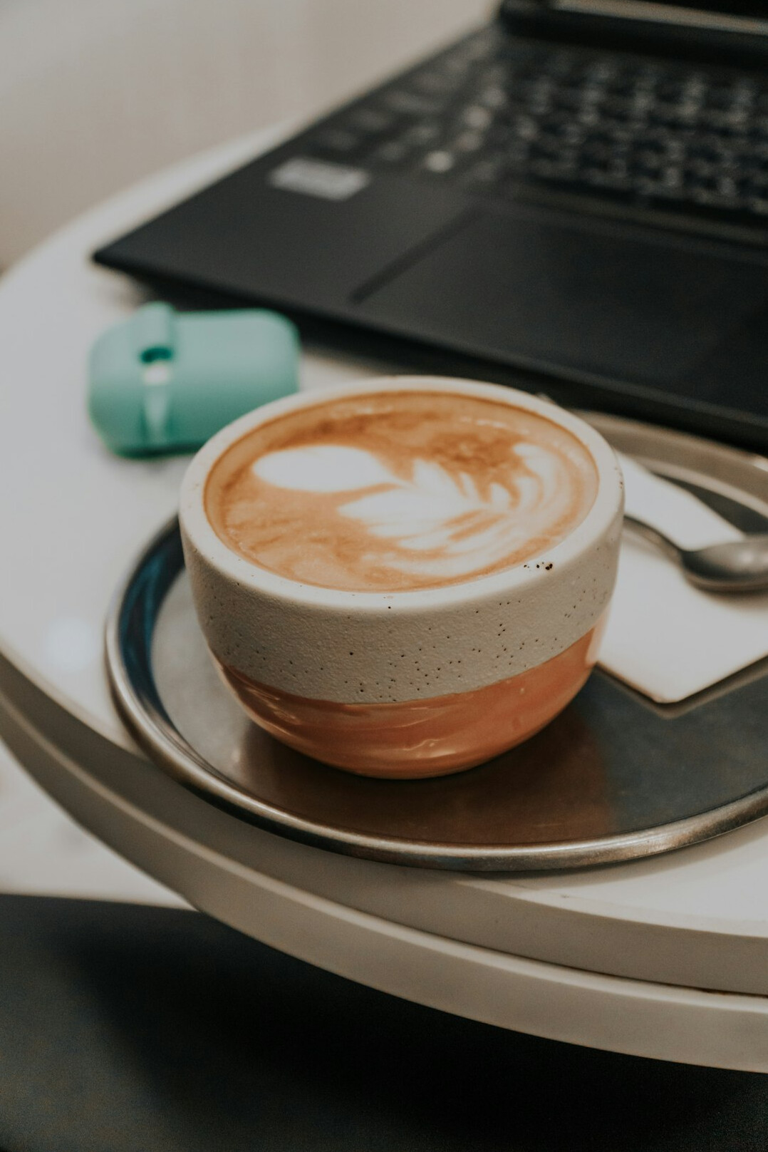 Laptop with code editor open beside a cup of coffee